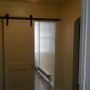 view from entry door into apartment from building hallway of bedroom door through living room