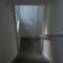 view down hallway stairs of coat closet