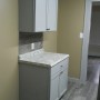 view of kitchen base cabinet and cupboard across from kitchen sink from side entry door